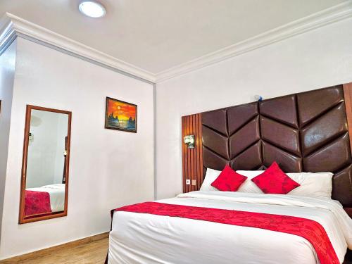 a bedroom with a large bed and a mirror at Reiz Continental Hotel, Abuja in Abuja