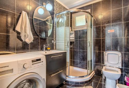 a bathroom with a washing machine and a toilet at Cretan Blue Bungalow Chania in Chania