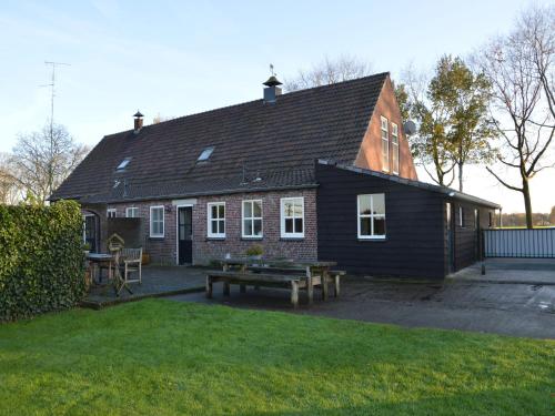 a black house with a picnic table in front of it at Farmhouse in Elsendorp near Forest Trails in Elsendorp