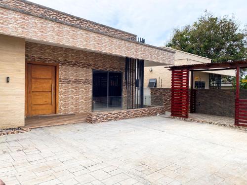 a brick building with a wooden door and a patio at Emmy's 3 Bedroom Apartment in Sakumona