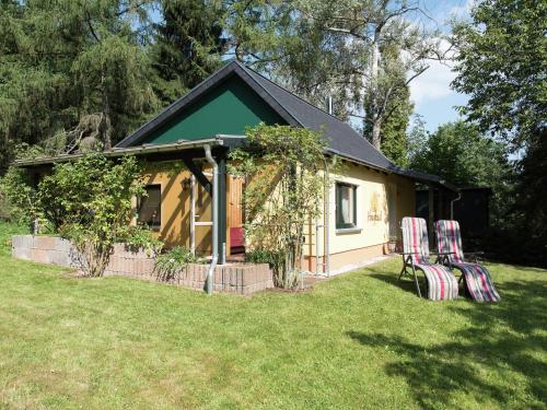 a small house with two chairs in front of it at Cozy Escape in Walthersdorf in Scheibenberg