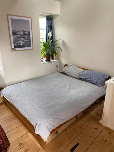 una cama en un dormitorio con ventana en 23 Leskinnick Terrace, en Penzance