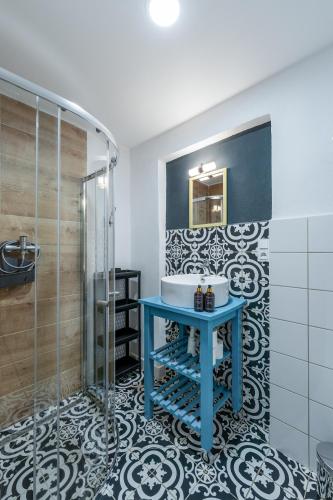 a bathroom with a blue sink and a shower at Penzion Medové údolí in Čábuze