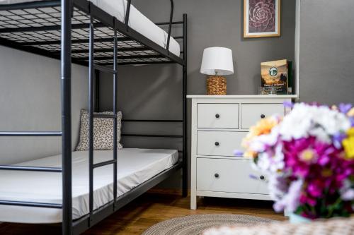 a bedroom with bunk beds and a dresser and flowers at Penzion Medové údolí in Čábuze