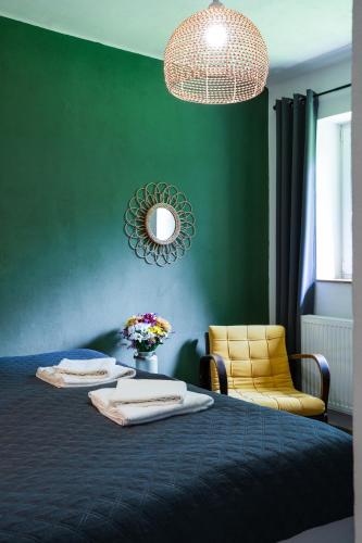 a bedroom with a blue bed and a yellow chair at Penzion Medové údolí in Čábuze
