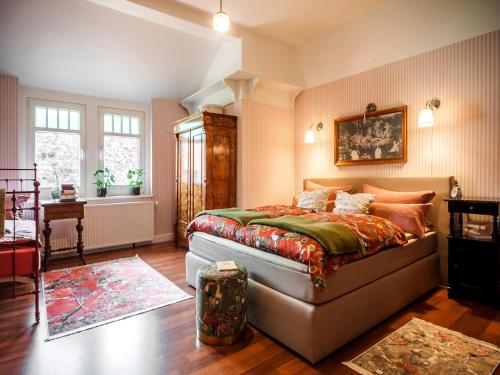 a bedroom with a bed and a table and windows at Timeless Charm in Gernrode in Gernrode - Harz