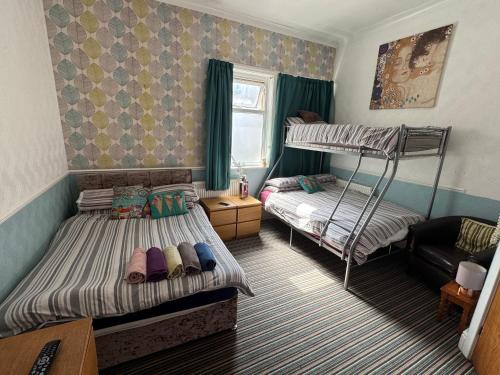 a bedroom with two bunk beds and a couch at The Pembroke in Blackpool