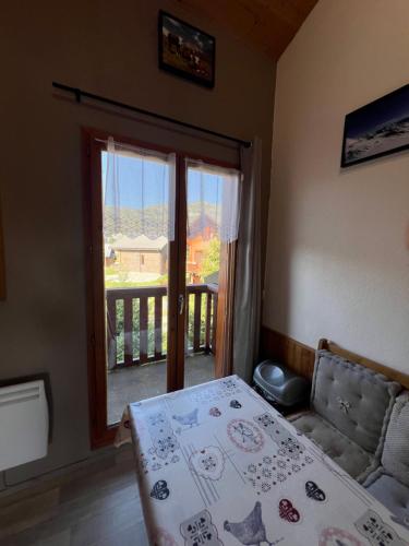 een slaapkamer met een bed en een raam met een balkon bij Charming duplex in La Toussuire