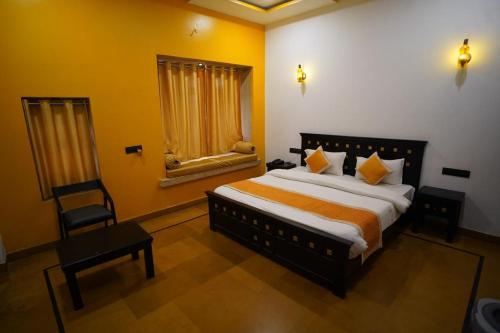 a bedroom with a large bed and a chair at Hotel Bhanwar Haveli in Jaisalmer