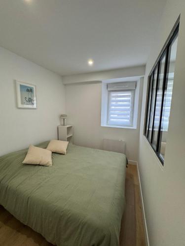 a bedroom with a bed and a window at Mallorca, plein centre avec parking in Reims