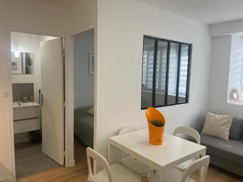 a white table with a vase on it in a room at Mallorca, plein centre avec parking in Reims