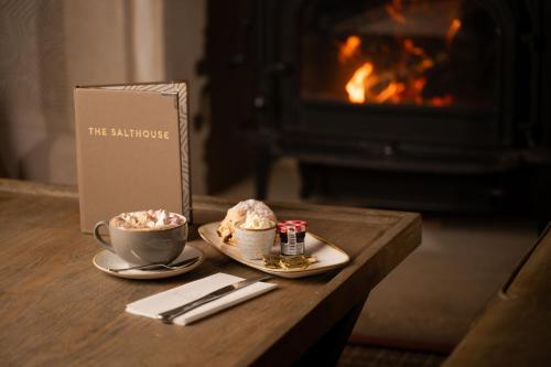 a coffee table with a cup of coffee and a book at The Salthouse Hotel in Ballycastle
