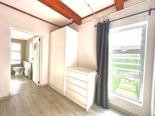 a bathroom with a toilet and a window at Harbor View Cottage in Hout Bay