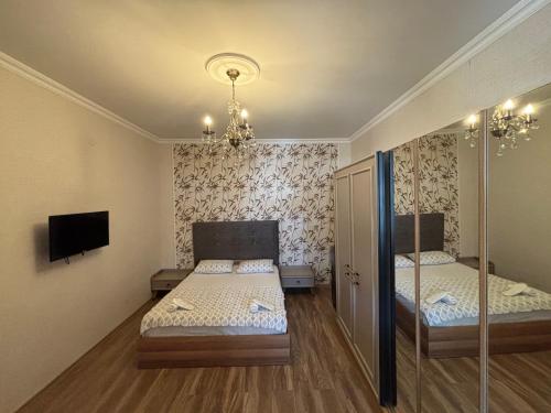 a small bedroom with two beds and a tv at Sunny Days in K'obulet'i