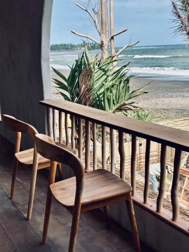 a wooden bench sitting on a balcony overlooking the beach at The Beachbreaks Medewi in Airsatang