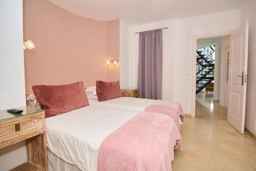 una camera da letto con un grande letto bianco con cuscini rossi di Casa Palmeras ad Adeje