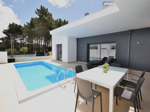 a dining area with a table and a swimming pool at Sunny Villa Near Óbidos w Beaches in Nadadouro