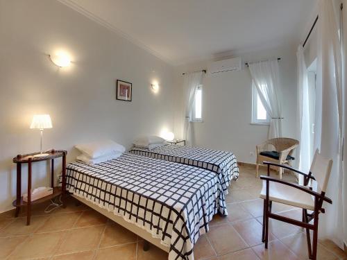 a bedroom with two beds and a table and chairs at Villa in Carvoeiro near Beach & Pool in Carvoeiro