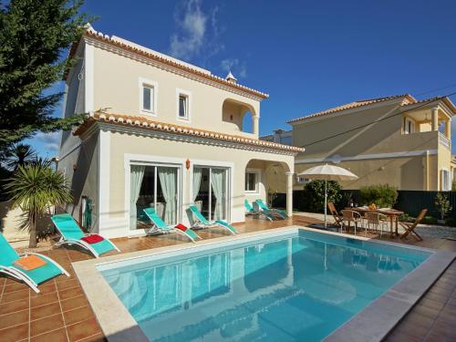 a villa with a swimming pool in front of a house at Villa in Carvoeiro near Beach & Pool in Carvoeiro