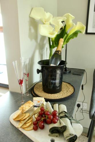 a table with a plate of cheese and a bottle of wine at Riverside Haven in Ardara in Ardara