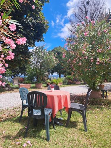 a table with a red tablecloth and chairs in a park at Country House Bucaneve in Rovolon