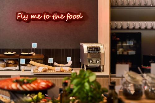 a sign that says fly me to the food in a bakery at ibis Styles Katowice Airport in Pyrzowice