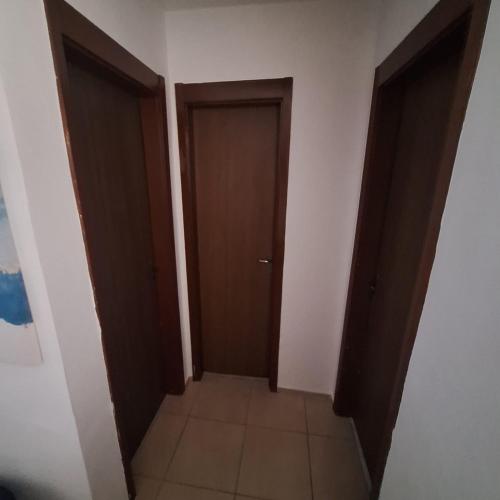 an empty hallway with two doors and a tile floor at Pedacinho de Lar in João Pessoa