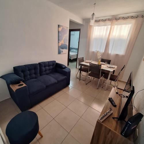 a living room with a blue couch and a table at Pedacinho de Lar in João Pessoa