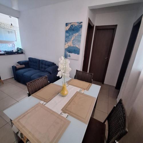 a living room with a table and a blue couch at Pedacinho de Lar in João Pessoa