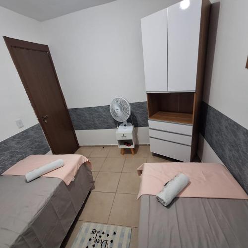 a small room with two beds and a fan at Pedacinho de Lar in João Pessoa