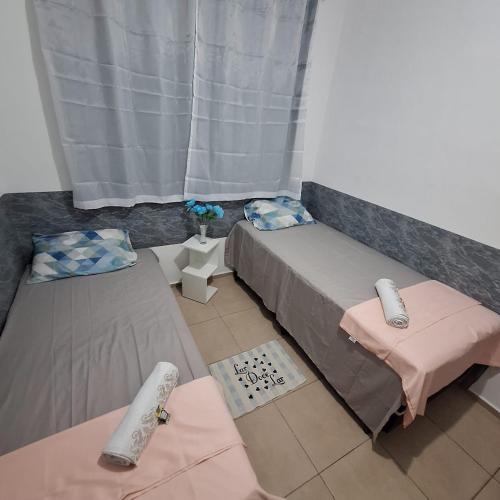 a room with two beds and a window at Pedacinho de Lar in João Pessoa