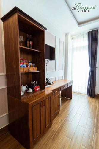 a kitchen with a large wooden cabinet in a room at Hodota Ankroet Hotel & Spa in Da Thanh