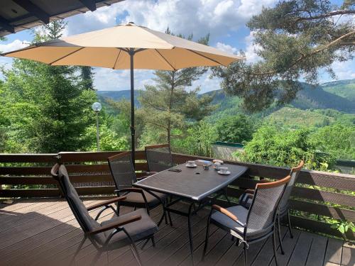 a table and chairs with an umbrella on a deck at Bungalow with View near Coo in Stavelot