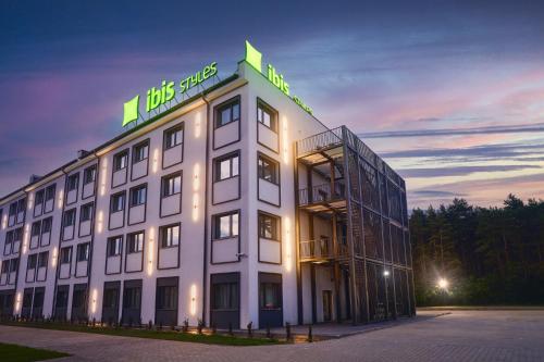a large white building with a sign on top of it at ibis Styles Katowice Airport in Pyrzowice