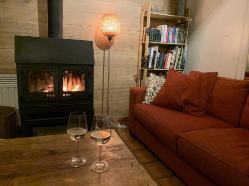 two wine glasses on a table in a living room with a fireplace at Bungalow with View near Coo in Stavelot