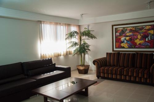 a living room with a couch and a coffee table at Copas Executive Hotel in Cascavel