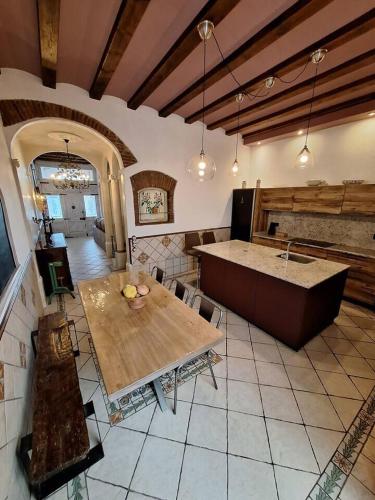 a kitchen with a wooden table and a counter at Marina Vila House, Masnou in Masnou