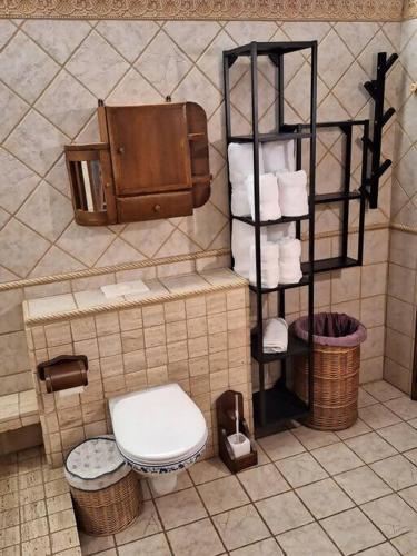 a bathroom with a toilet and a rack of towels at Marina Vila House, Masnou in Masnou