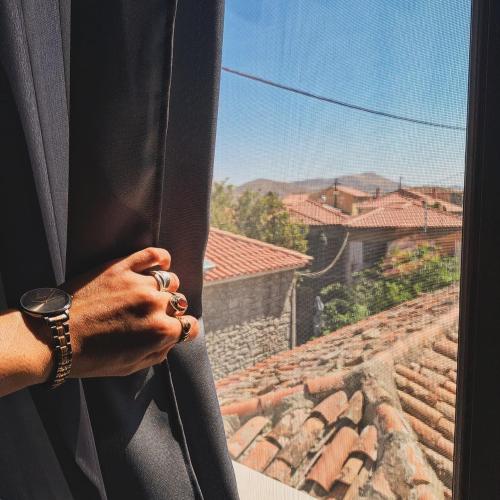 a person holding a window looking out at a roof at Mythos Home in Mirina