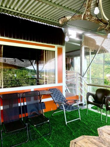 two chairs and a table on a porch with grass at Homestay Đồi Sương Trắng in Da Lat