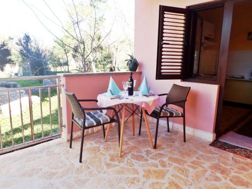 eine Terrasse mit Tisch und Stühlen auf einem Balkon in der Unterkunft Apartments in Starigrad-Paklenica 41707 in Starigrad-Paklenica