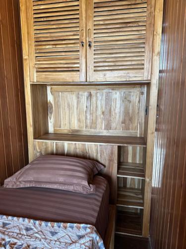 a small bed in a room with wooden walls at The Beachbreaks Medewi in Airsatang