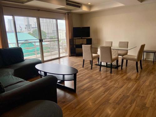 a living room with a couch and a table and chairs at ศรีย่าน เรสซิเดนซ์ Sriyan Residence in Dusit