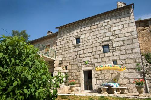 a stone building with a bench in front of it at Gites de france aux badieux in Les Badieux