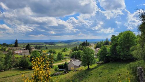 a small village in a green field with trees at Gites de france aux badieux in Les Badieux