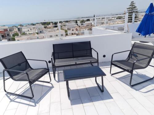 three chairs and a table on a roof at Maison Dar Khalil in Hammamet