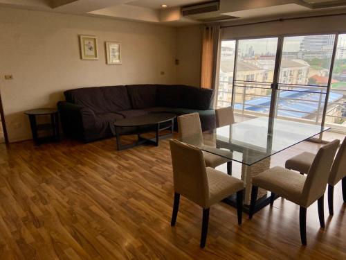 a living room with a glass table and a couch at ศรีย่าน เรสซิเดนซ์ Sriyan Residence in Dusit
