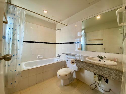 a bathroom with a tub and a toilet and a sink at ศรีย่าน เรสซิเดนซ์ Sriyan Residence in Dusit