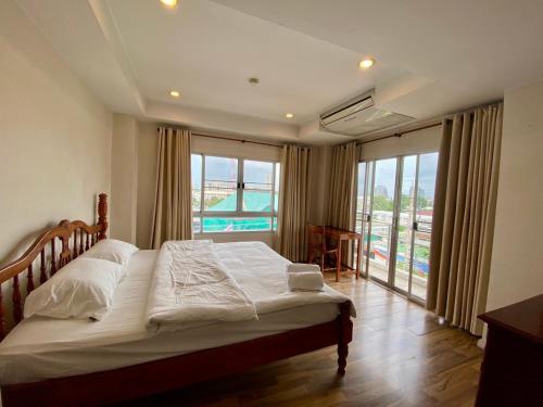 a bedroom with a bed and a large window at ศรีย่าน เรสซิเดนซ์ Sriyan Residence in Dusit