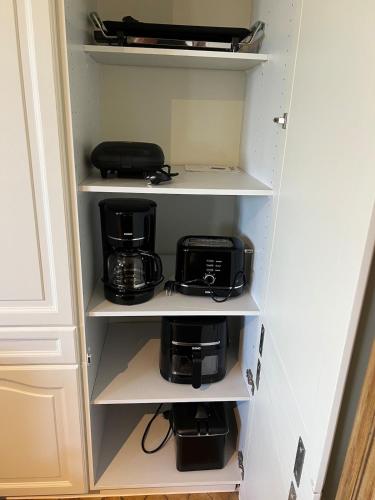 a cupboard with a coffee maker and a toaster at Maison Frieda in Oostkamp